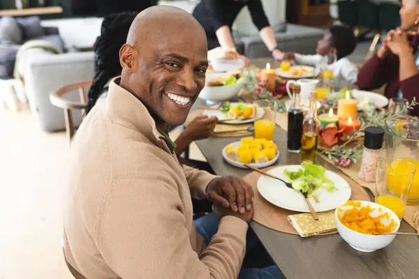 感謝祭のディナーテーブルで笑顔で家族とアフリカ系アメリカ人の父の肖像画 感謝祭 お祝い トグルネスとライフスタイル 変わらない — ストック写真