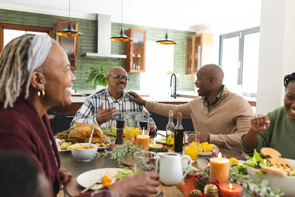 African american parents, children and grandparents celebrating at thanksgiving dinner. Thanksgiving, celebration, meal, home, family, togetherness, unaltered.