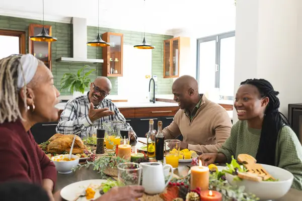 African american parents, children and grandparents celebrating at thanksgiving dinner. Thanksgiving, celebration, meal, home, family, togetherness, unaltered.