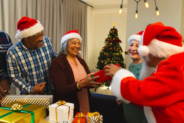 Homem Biracial Feliz Roupas Papai Noel Dando Presentes Para Amigos — Fotografia de Stock