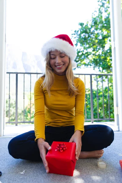 Glückliche Kaukasische Frau Mit Weihnachtsmütze Die Auf Dem Boden Sitzt — Stockfoto