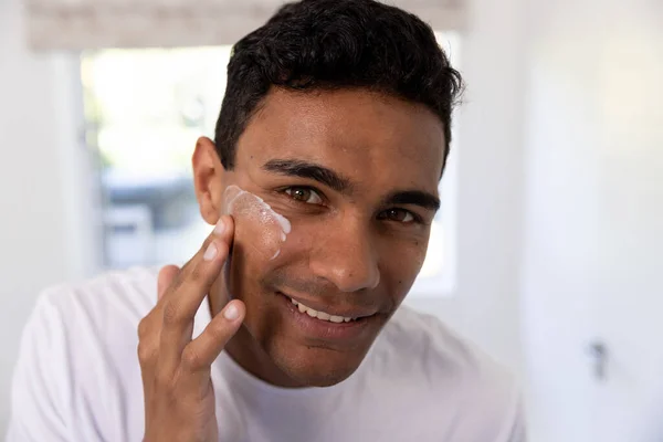 Homem Biracial Feliz Aplicando Creme Facial Banheiro Casa Autocuidado Estilo — Fotografia de Stock