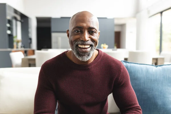 ハッピーアフリカ系アメリカ人成熟した男性ビデオ通話 自宅の晴れたリビングルームで笑顔 コミュニケーション テクノロジー 家庭生活 ライフスタイル — ストック写真