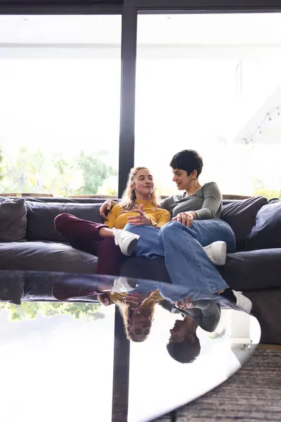 Happy Biracial Lesbian Couple Sitting Couch Talking Sunny Living Room Stock Image