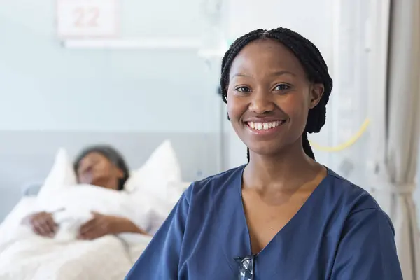 Portrait of happy african american female doctor in hospital room. Medicine, healthcare and medical services, unaltered.