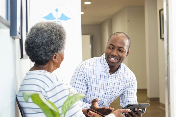 African American Male Doctor Using Tablet Talking Senior Woman Hospital — Stock Photo, Image