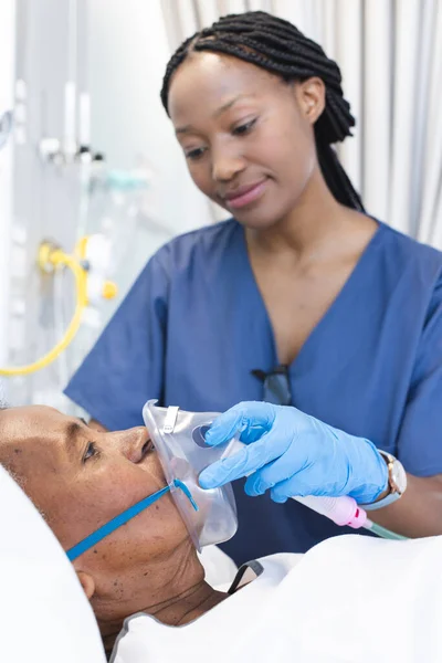 アフリカ系アメリカ人女性医師が 病院の患者さんに酸素マスクを塗布しています 医療サービス 変わらない — ストック写真