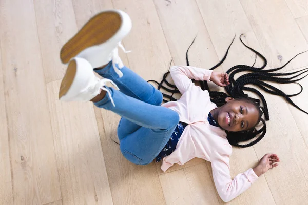 Счастливая Африканская Американская Девушка Лежит Полу Ногами Воздухе Дома Скопировать — стоковое фото