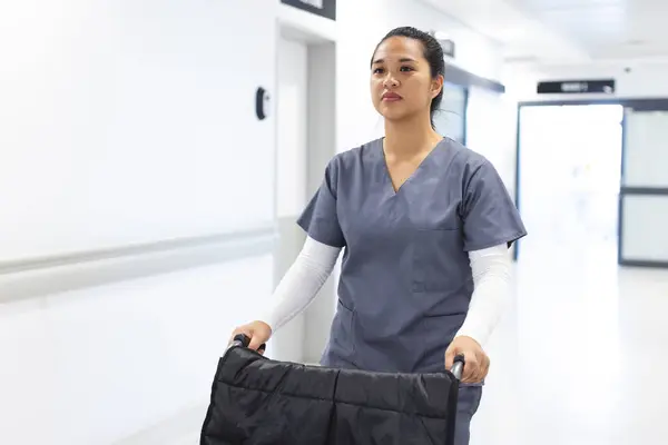 Ameliyat Önlüğü Giymiş Çift Irklı Kadın Doktor Hastanede Tekerlekli Sandalyeyi — Stok fotoğraf
