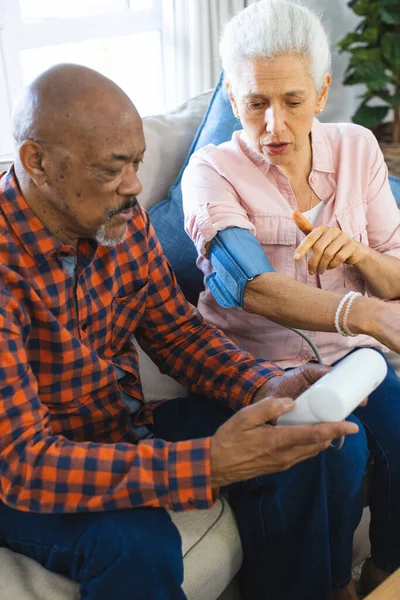 Diverse Senior Man Testing Blood Pressure Senior Woman Sunny Living — Stock Photo, Image