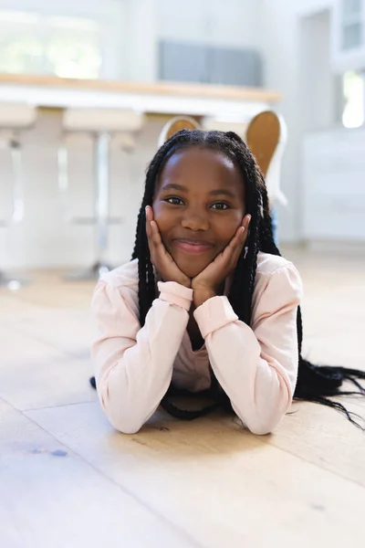ハッピーアフリカ系アメリカ人の女の子が床に横たわり 自宅で手を挙げてスペースをコピーします 子供時代 家庭生活 変わらない — ストック写真