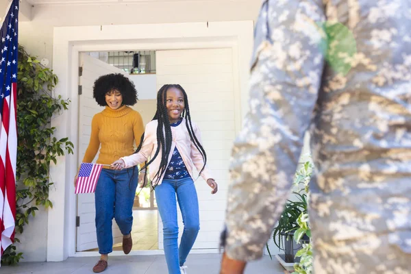 ハッピーアフリカ系アメリカ人の妻と娘は アメリカの国旗 コピースペースで屋外で男性兵士を歓迎します トータル 愛国心と国籍 変わらない — ストック写真