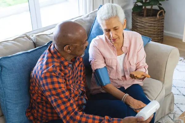 Diverse Senior Man Testing Blood Pressure Senior Woman Sunny Living — Stock Photo, Image