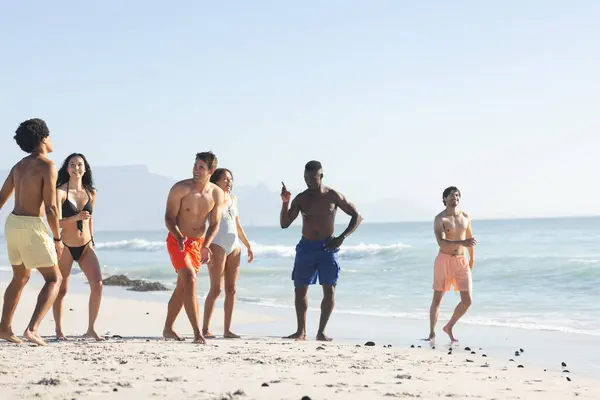 多样化的朋友圈在海滩上享受一天的时光 在阳光和海风的熏陶下 空气中充满了笑声和谈话 — 图库照片