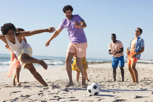 不同的朋友在海滩上玩着一场有趣的足球比赛 户外环境抓住了海上体育和休闲的乐趣 — 图库照片