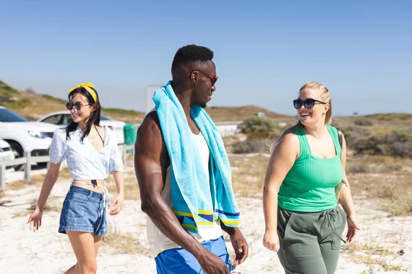 白人女性 白人女性 アフリカ系アメリカ人の男性を含む友人の多様なグループは ビーチに歩き 晴れた日を変えずに楽しんでいます — ストック写真