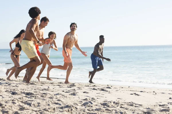 Diversos Amigos Disfrutan Una Animada Carrera Una Playa Soleada Con —  Fotos de Stock
