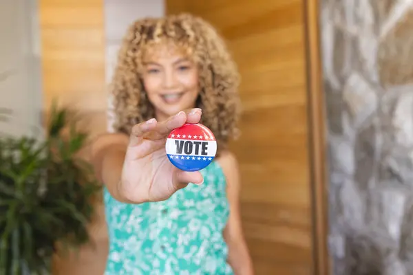 Vote 徽章的年轻的白人妇女 有复制空间 她的姿态突出了参加选举的重要性 免版税图库图片