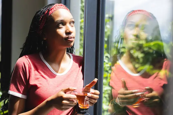 Eine Junge Afroamerikanerin Blickt Aus Einem Fenster Und Hält Eine — Stockfoto