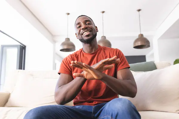 Ein Afroamerikaner Rotem Hemd Sitzt Auf Einem Sofa Lacht Und — Stockfoto