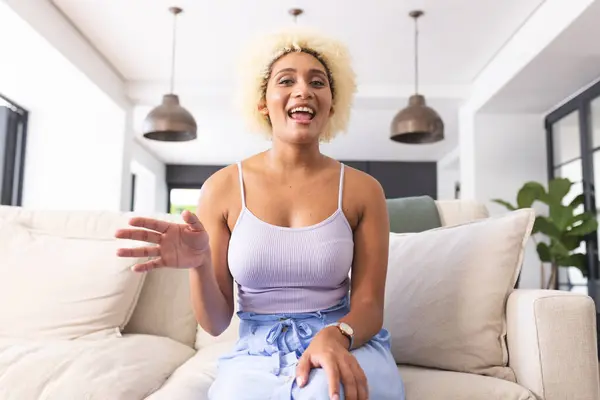 Young Biracial Woman Curly Blonde Hair Smiles Gestures While Sitting — Stock Photo, Image