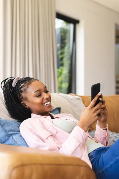 Young African American Woman Lounges Sofa Smiling Her Phone Copy — Stock Photo, Image