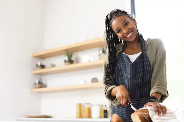 Young African American Woman Slices Bread Bright Kitchen Copy Space — Stock Photo, Image