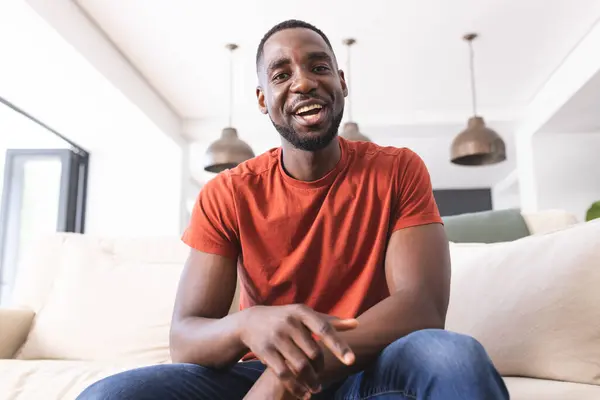 Ein Afroamerikaner Orangefarbenem Hemd Lächelt Freundlich Während Auf Einer Couch — Stockfoto