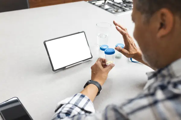 Üst Sınıftan Bir Adam Boş Ekranlı Tabletin Yanında Ilaçları Inceliyor Telifsiz Stok Imajlar