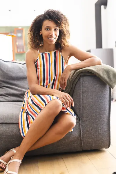 Biracial Woman Striped Dress Sits Couch She Exudes Relaxed Content — Stock Photo, Image