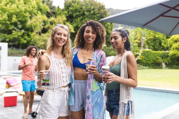 Three Diverse Female Friends Enjoy Poolside Gathering Holding Drinks Smiling — Stock Photo, Image
