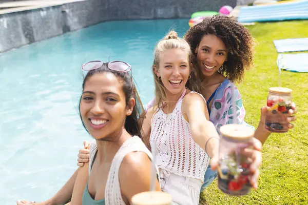 Diverse Female Friends Enjoying Sunny Poolside Gathering Holding Refreshing Drinks — Stock Photo, Image