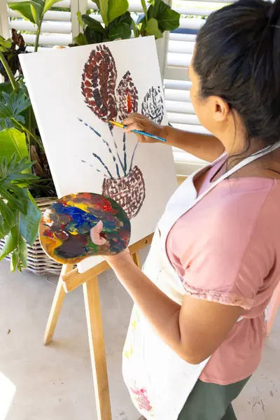Wanita Birasial Dewasa Melukis Kanvas Rumah Mengenakan Celemek Dia Memiliki Stok Gambar Bebas Royalti