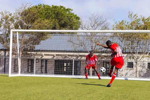 Два Афроамериканских Молодых Спортсмена Играют Футбол Открытом Воздухе Один Бьет — стоковое фото
