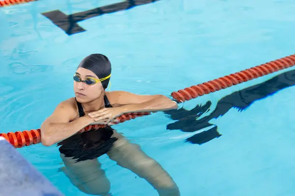 Joven Nadadora Birracial Que Descansa Borde Piscina Interiores Con Gafas Fotos De Stock
