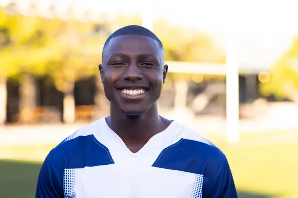 Afrikansk Amerikansk Ung Mannlig Idrettsutøver Som Står Idrettsanlegg Med Rugbytrøye royaltyfrie gratis stockbilder