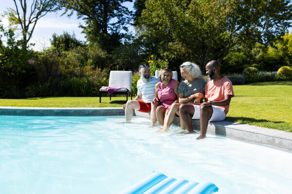 Group of senior friends sitting by pool, enjoying sunny day together. seniors, leisure, poolside, relaxation, summer, outdoors, unaltered — Stock Image Group Senior Friends Sitting Pool Enjoying Sunny Day Together Seniors Royalty Free Stock Photos