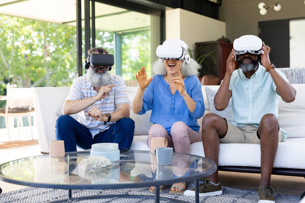 At home, Diverse group of seniors using VR headsets, enjoying virtual reality experience. Technology, entertainment, elderly, innovation, unaltered — Stock Image Home Diverse Group Seniors Using Headsets Enjoying Virtual Reality Experience Stock Picture