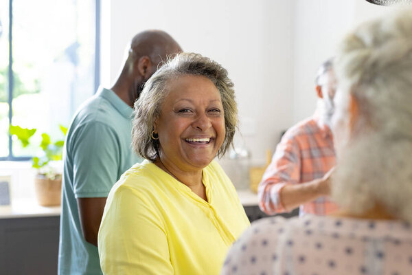 Smiling senior woman enjoying time with friends in cozy home gathering. leisure, socializing, happiness, unaltered — Stock Image Smiling Senior Woman Enjoying Time Friends Cozy Home Gathering Leisure Stock Image