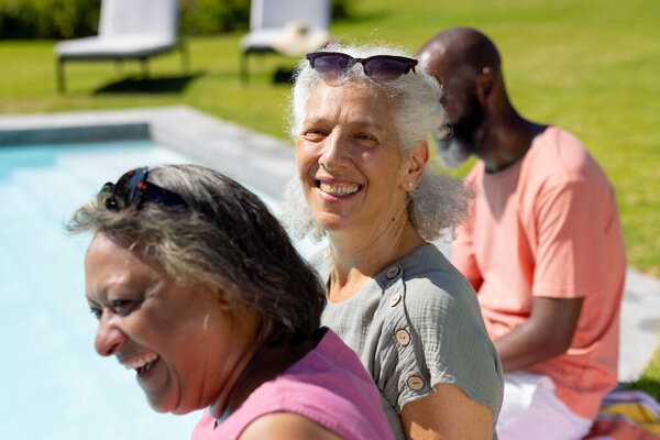 Smiling and relaxing by pool, diverse group of senior friends enjoying sunny day. Seniors, relaxation, friendship, outdoor, leisure, summer, fun, vacation, unaltered — Stock Image Smiling Relaxing Pool Diverse Group Senior Friends Enjoying Sunny Day Royalty Free Stock Photos