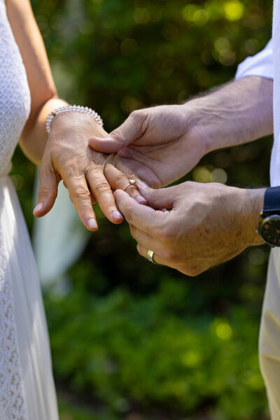 Exchanging wedding rings, senior bride and groom celebrating marriage ceremony outdoors with joy. — Stock Image Exchanging Wedding Rings Senior Bride Groom Celebrating Marriage Ceremony Outdoors Stock Photo