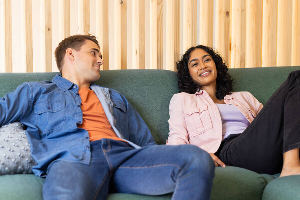 Relaxing on couch, young couple smiling and enjoying time together indoors. relaxation, happiness, leisure, bonding, living room, comfort — Stock Image Relaxing Couch Young Couple Smiling Enjoying Time Together Indoors Relaxation Stock Image