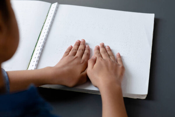 Hands of biracial schoolgirl reading braille book in school class, with copy space. Education, childhood, elementary school, inclusivity and learning concept. — Stock Image Hands Biracial Schoolgirl Reading Braille Book School Class Copy Space Stock Photo
