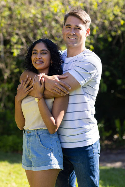 Young couple embracing and smiling outdoors, enjoying sunny day together. Love, happiness, romantic, togetherness, leisure, relationship — Stock Image Young Couple Embracing Smiling Outdoors Enjoying Sunny Day Together Love Royalty Free Stock Images
