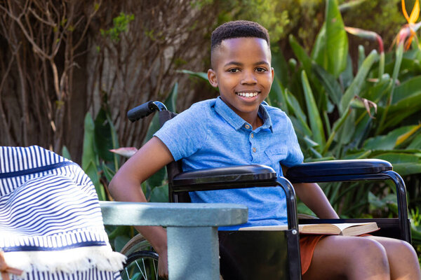 Portrait Smiling African American Schoolboy Wheelchair Sitting Garden Copy Space Stock Photo