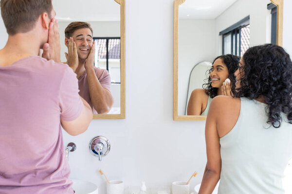 Smiling couple in bathroom, applying skincare products while looking in mirror. Beauty, routine, morning, grooming, cosmetics, wellness — Stock Image Smiling Couple Bathroom Applying Skincare Products While Looking Mirror Beauty Royalty Free Stock Photos