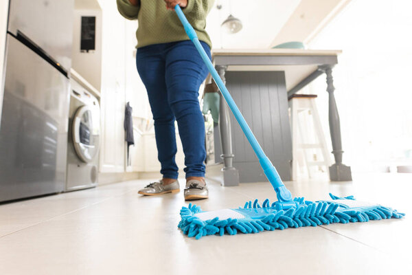 African american woman cleaning floor with mop at home. Domestic life, retirement, cleaning and lifestyle, unaltered. — Stock Image African American Woman Cleaning Floor Mop Home Domestic Life Retirement Stock Photo
