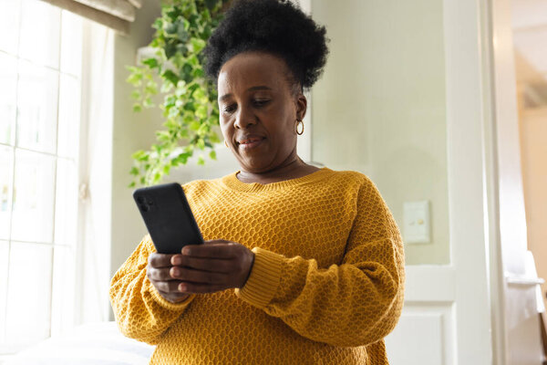 Busy senior african american woman using smartphone at home. Domestic life, retirement, technology and lifestyle, unaltered. — Stock Image Busy Senior African American Woman Using Smartphone Home Domestic Life Royalty Free Stock Images