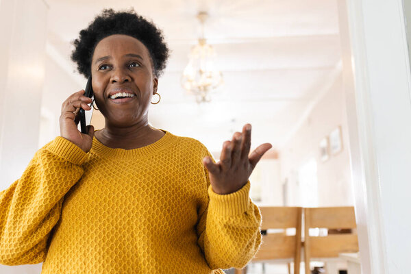 Happy senior african american woman talking on smartphone at home. Domestic life, retirement, technology and lifestyle, unaltered. — Stock Image Happy Senior African American Woman Talking Smartphone Home Domestic Life Stock Photo