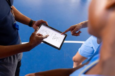 Basketball male coach using tablet to discuss game strategy with players. team, technology, discussion, sports clipart